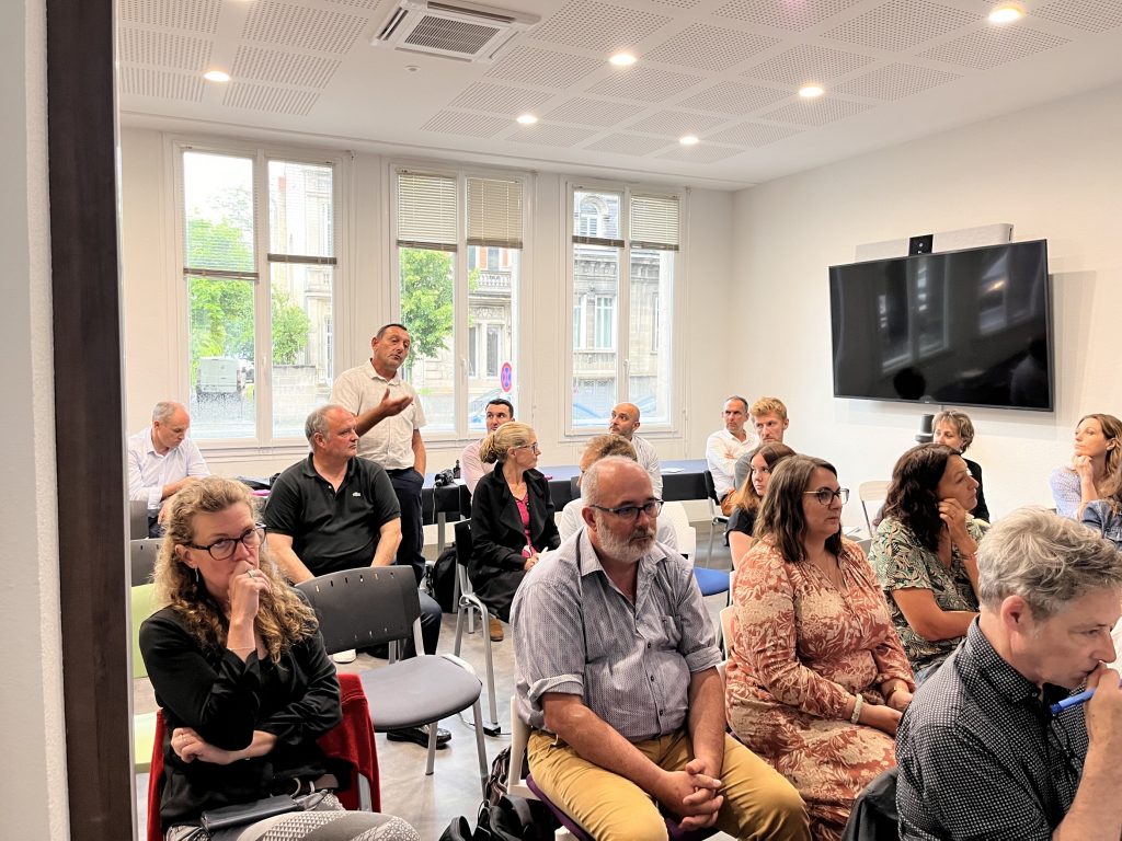 Participants assis dans une salle lors de la journée URIOPSS, écran au fond